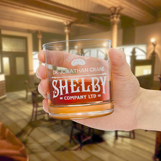Hand holding Personalized 10 oz rocks glass with Shelby Company Limited Peaky Blinders inspired logo and custom name.