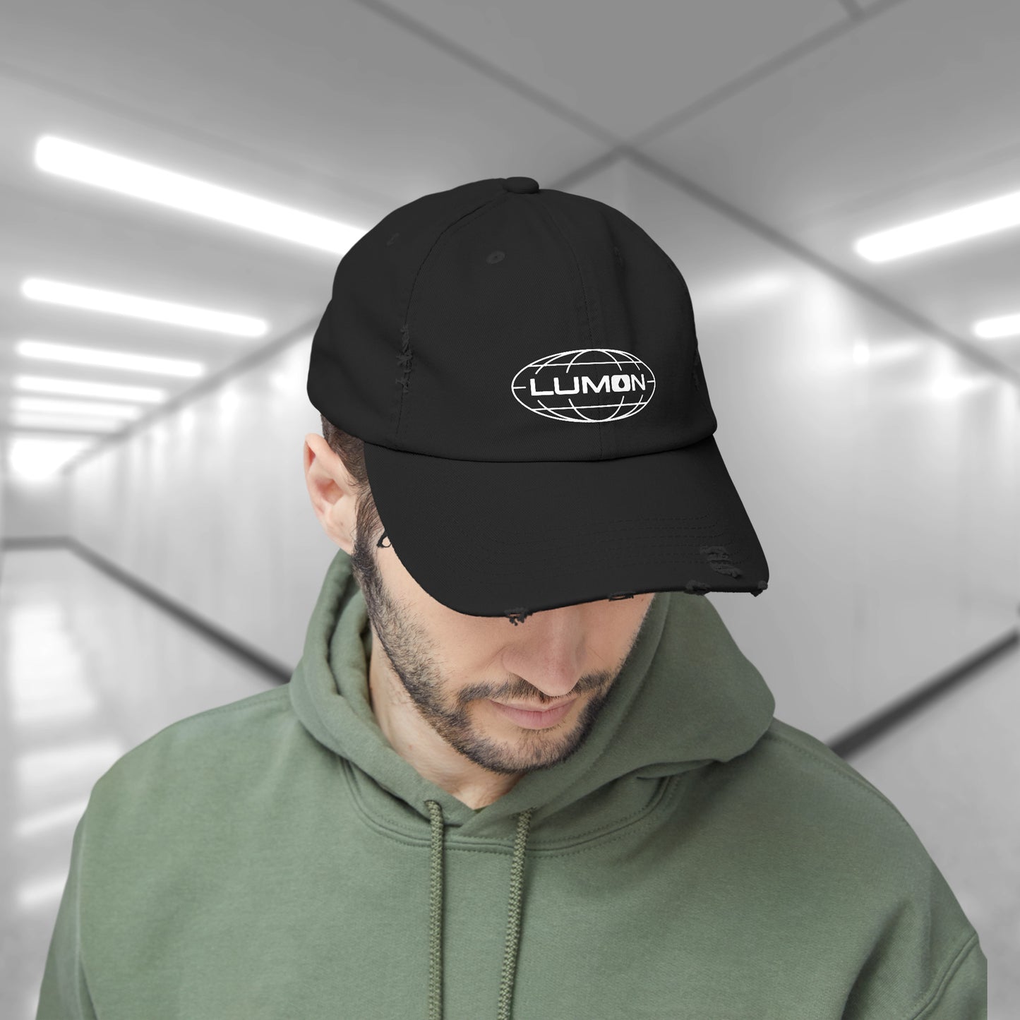 Male model wearing a black District DT600 Vintage Distressed Baseball Cap with the Lumon Industries logo from the show Severance.

