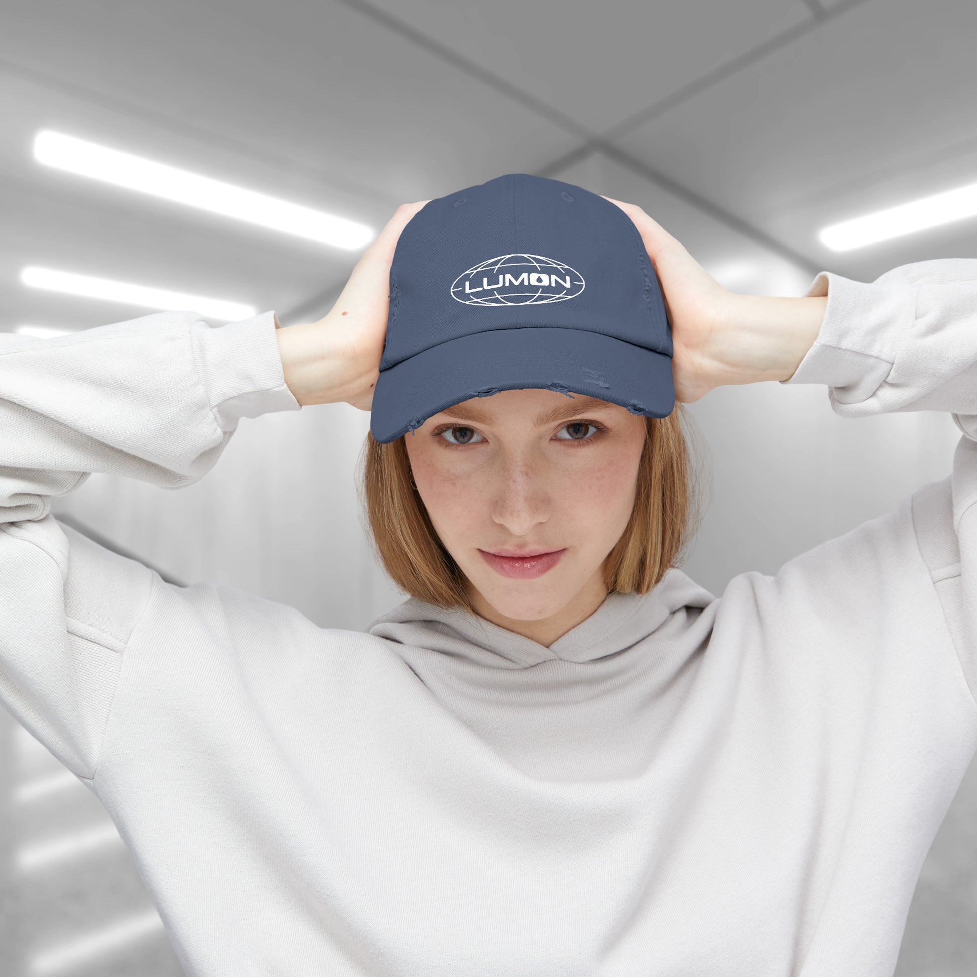 Femmale model wearing a Scotland blue District DT600 Vintage Distressed Baseball Cap with the Lumon Industries logo from the show Severance.