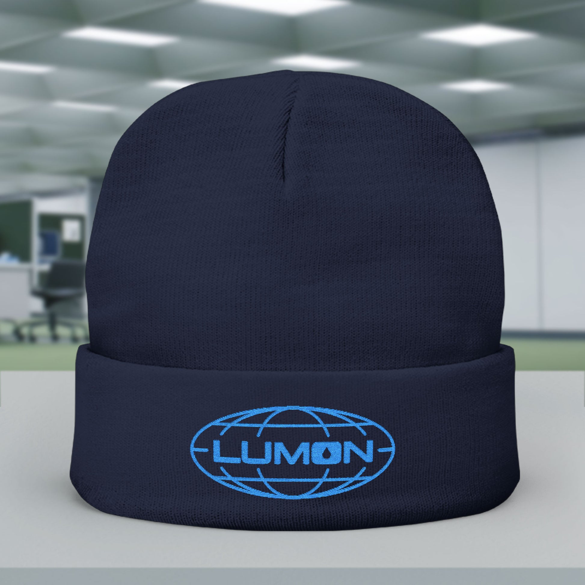 Front of Navy knit beanie with embroidered blue Lumon Industries logo from Apple TV’s Severance.