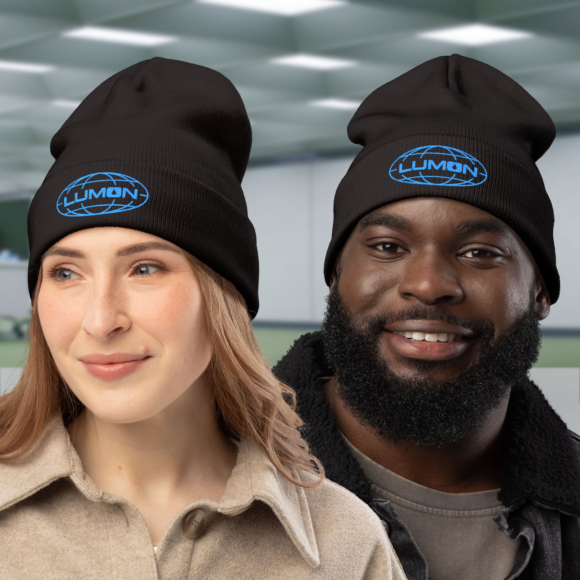Two peeple wearing black knit beanies with embroidered blue Lumon Industries logo from Apple TV’s Severance.