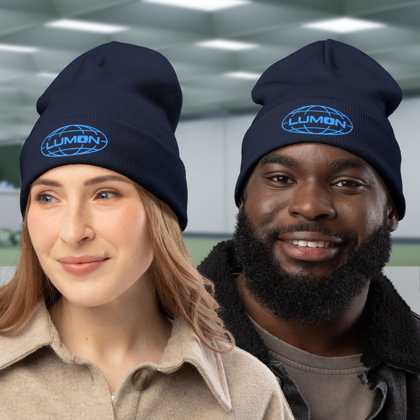 Two peeple wearing navy knit beanies with embroidered blue Lumon Industries logo from Apple TV’s Severance.