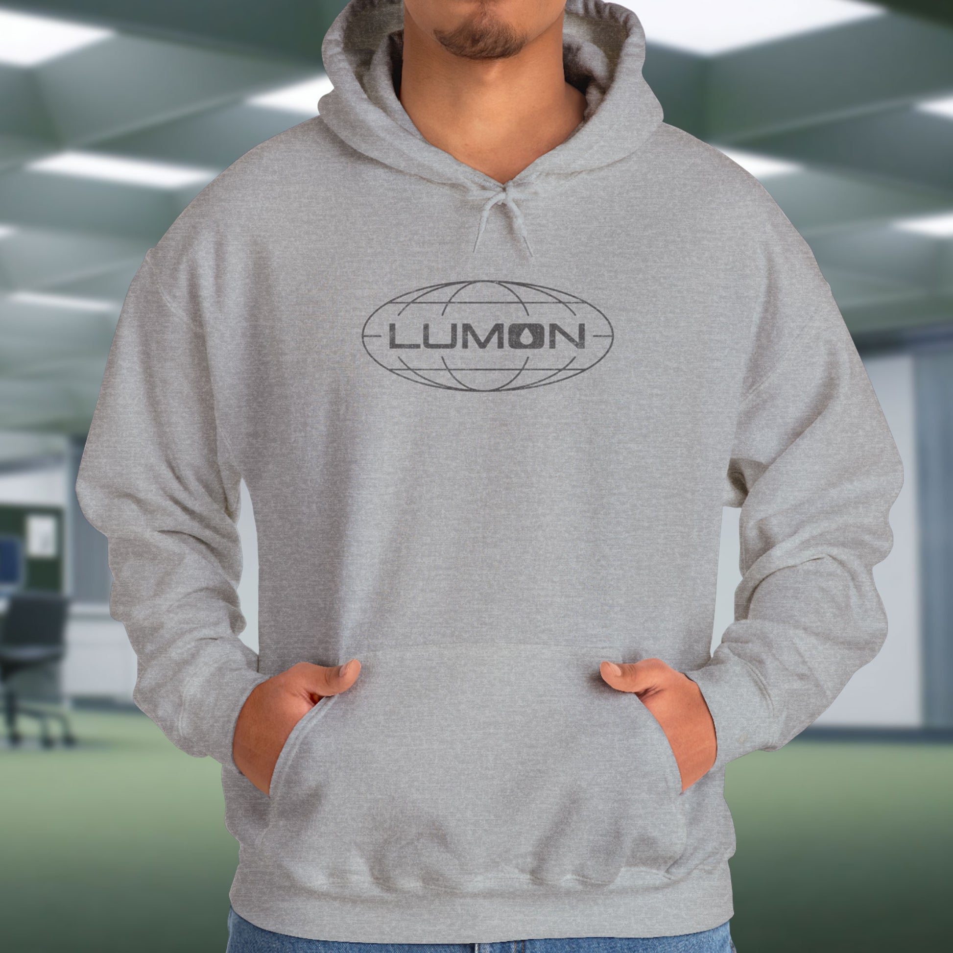 Model wearing a Sport Heather Gray colored Soft Unisex Heavy Blend Hooded Sweatshirt featuring the fictional Lumon Industries logo from the Apple TV show Severance.