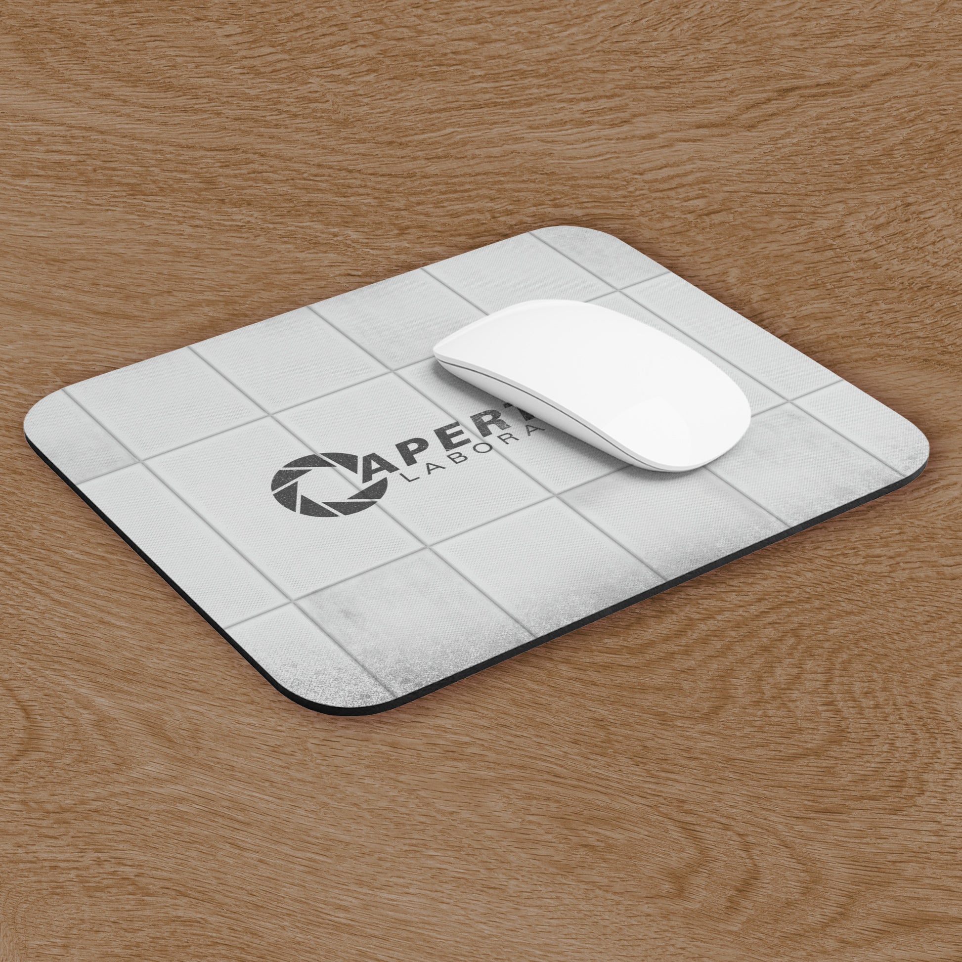 Angled view of a Mouse pad featuring Aperture Laboratories logo with a grungy panel wall design, shown with mouse on a desk.