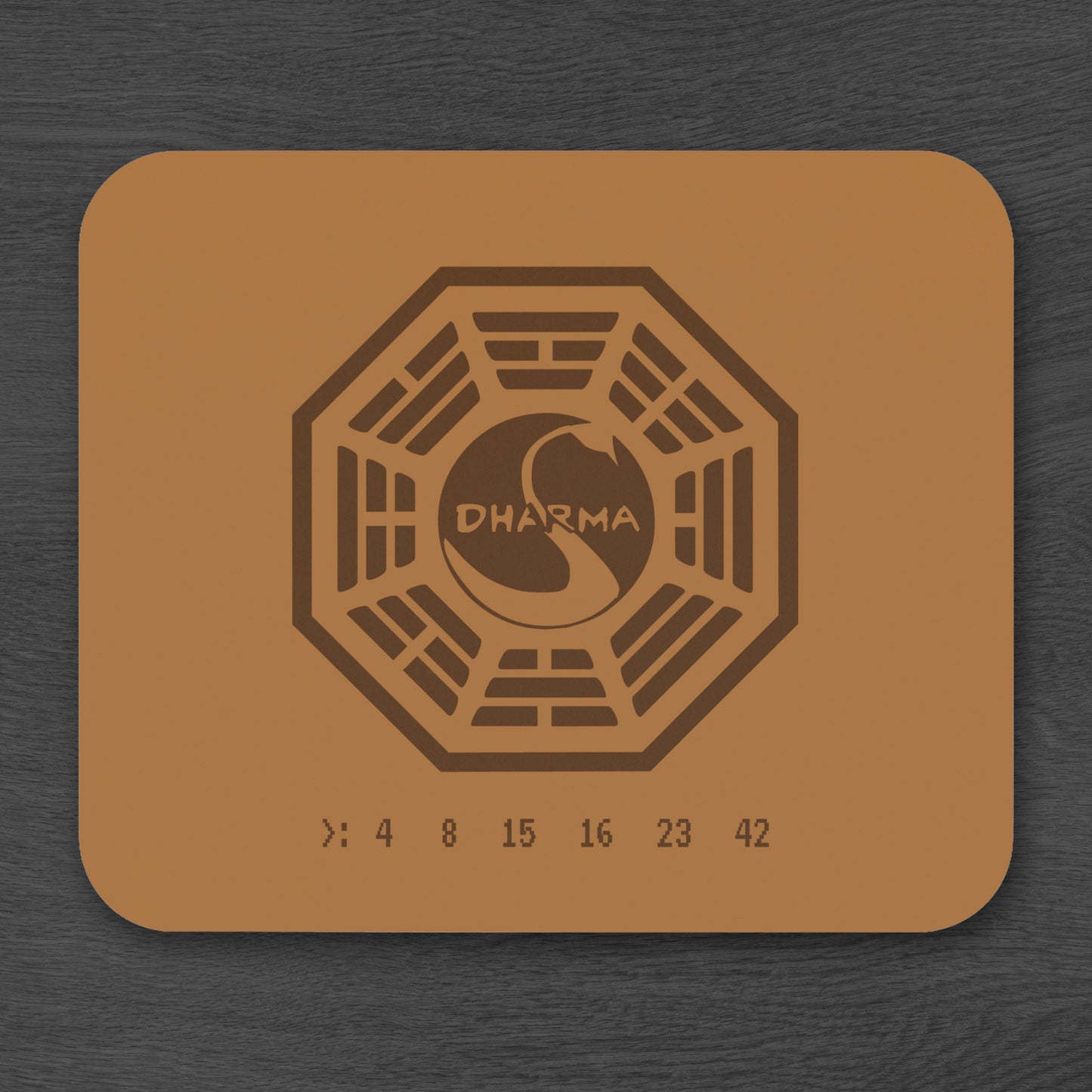 Topdown view of tan 9x8 mouse pad with Dharma Initiative Swan Station logo and hatch numbers from TV show Lost, on a desk