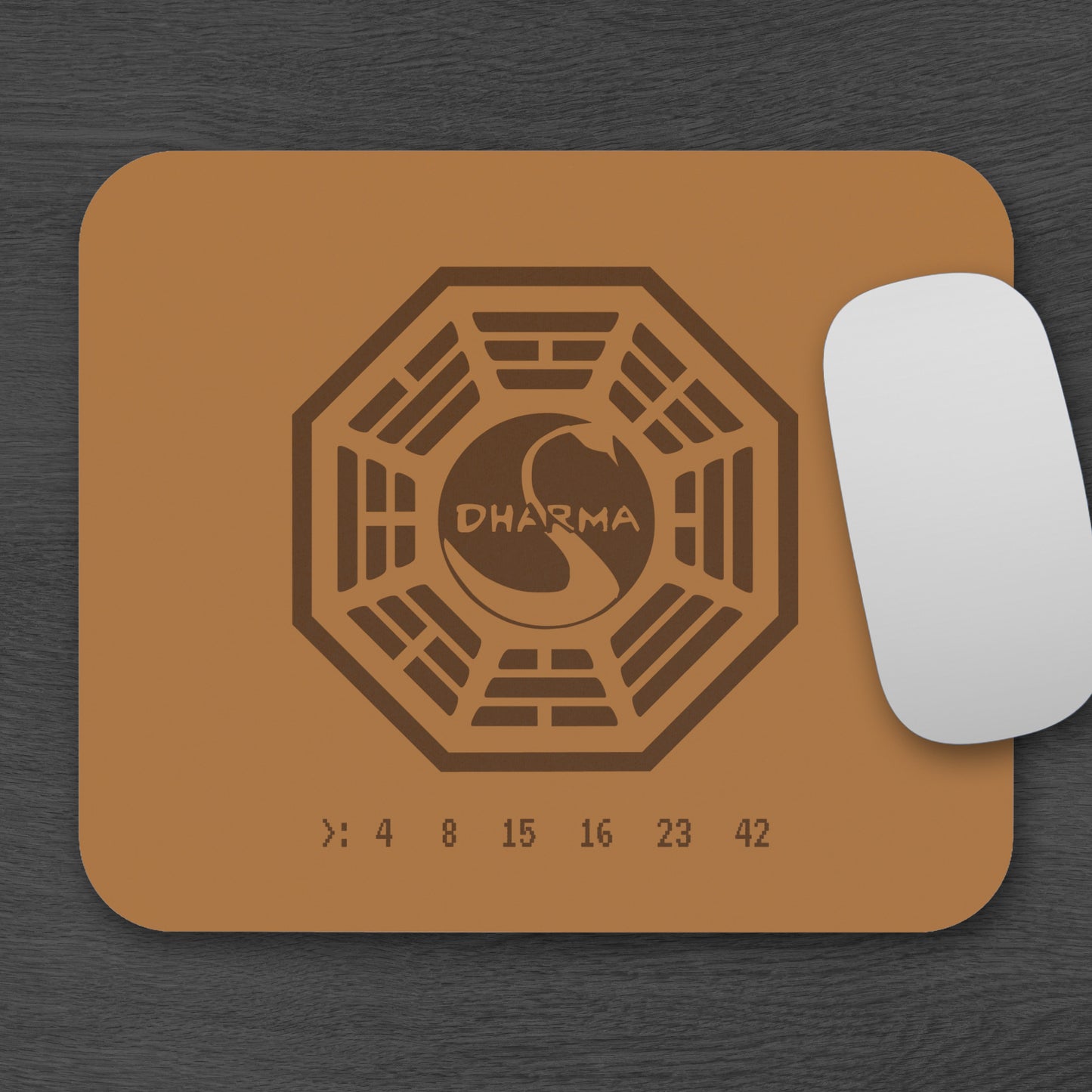 Topdown view of tan 9x8 mouse pad with Dharma Initiative Swan Station logo and hatch numbers from TV show Lost, on a desk with a mouse