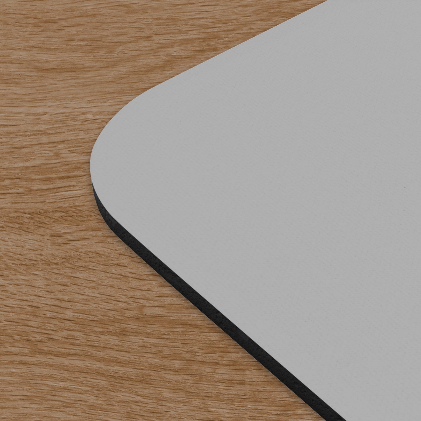 Closeup corner view of Office Space Initech logo mouse pad on wooden desk.