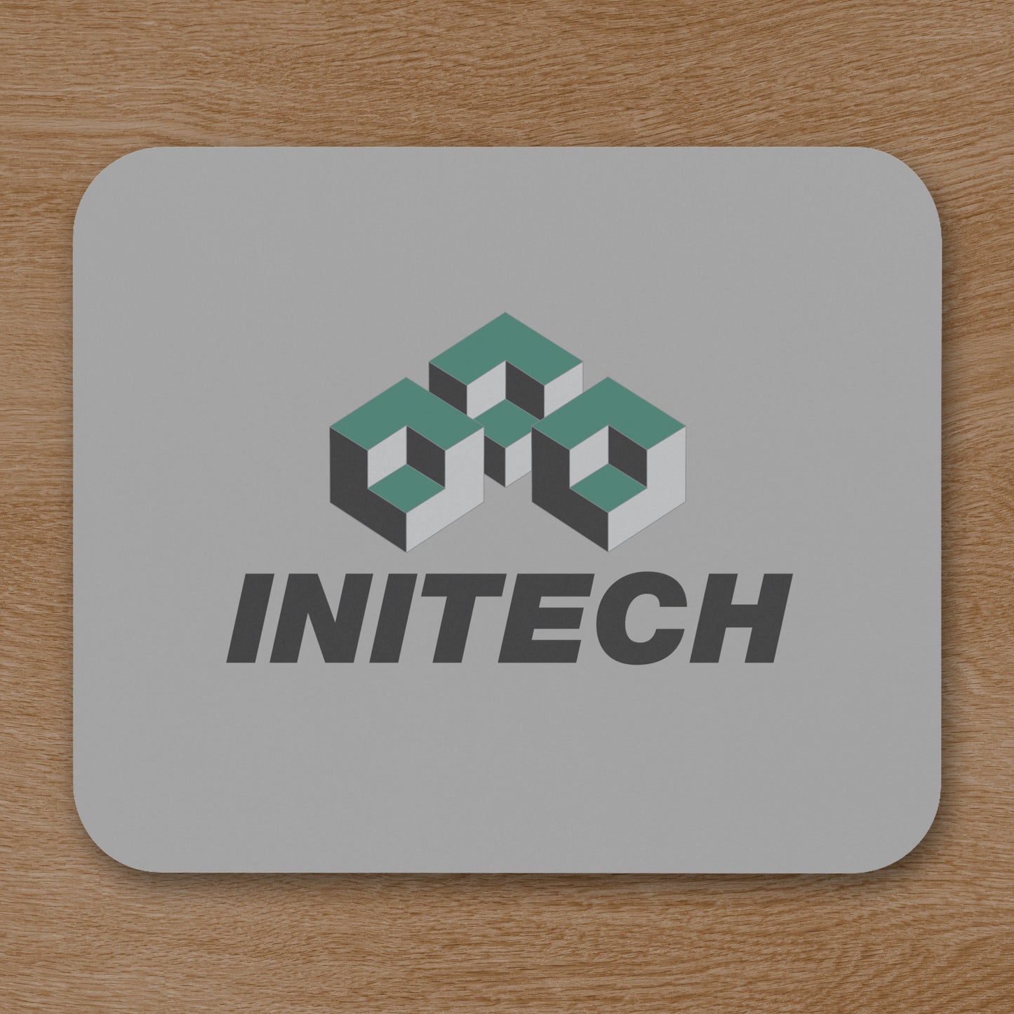 Office Space Initech logo mouse pad on wooden desk.