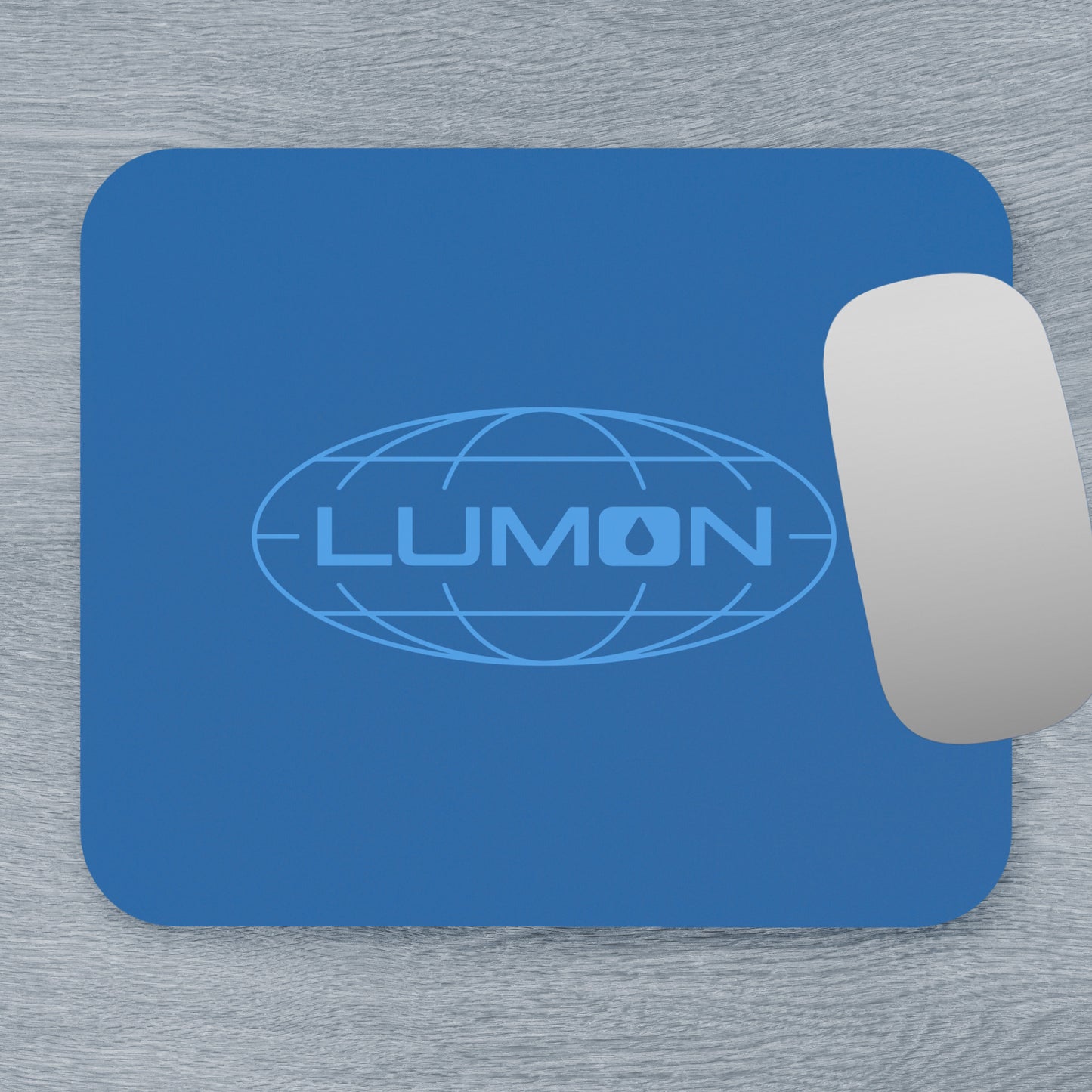 Top down view of a 9x8 modern blue Mouse pad with the Lumon Industries logo from the TV show Severance, next to a MacBook.