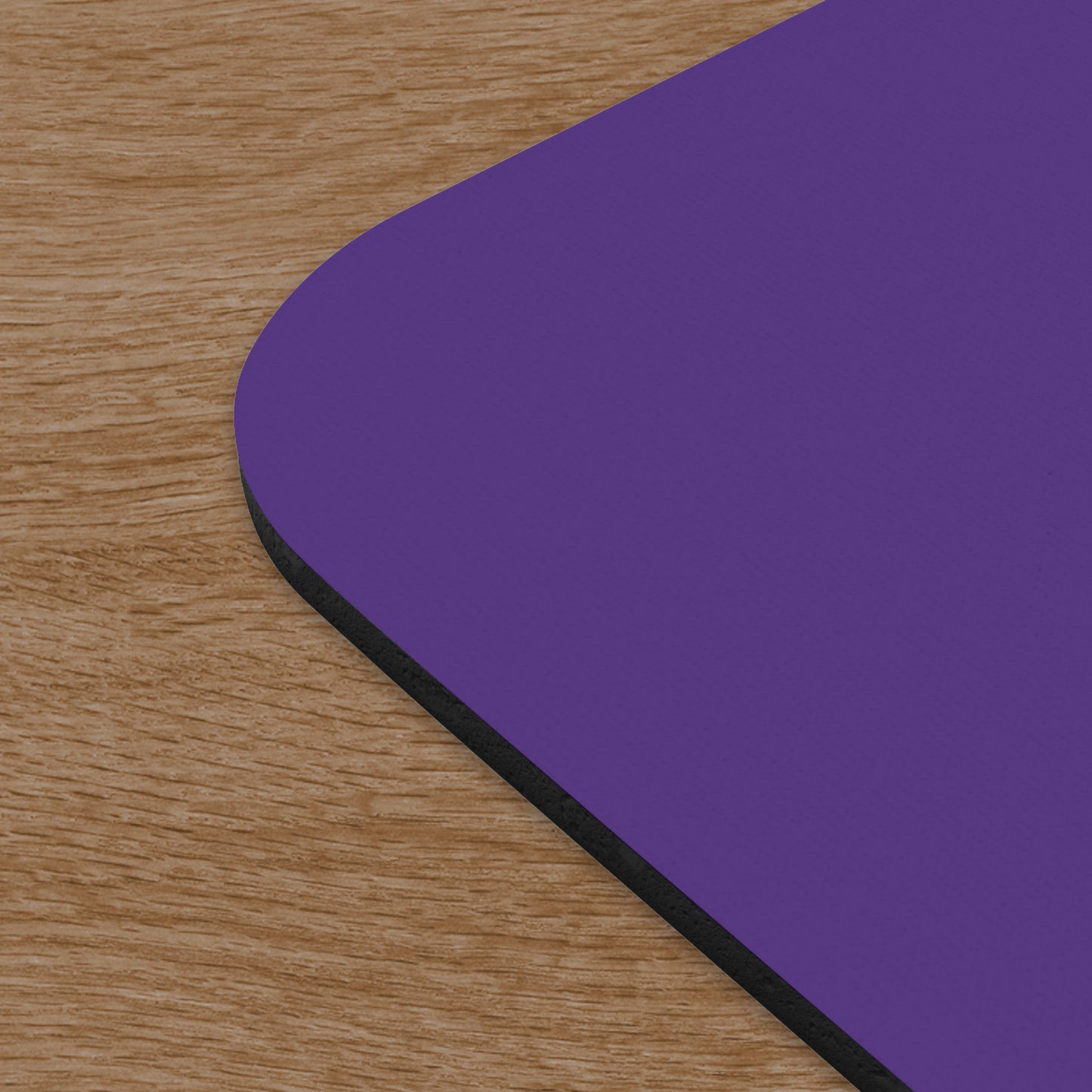 Angled corner view of Purple 9x8 mouse pad featuring the Pierpoint & Co. logo inspired by the HBO series Industry, shown on wooden desk.