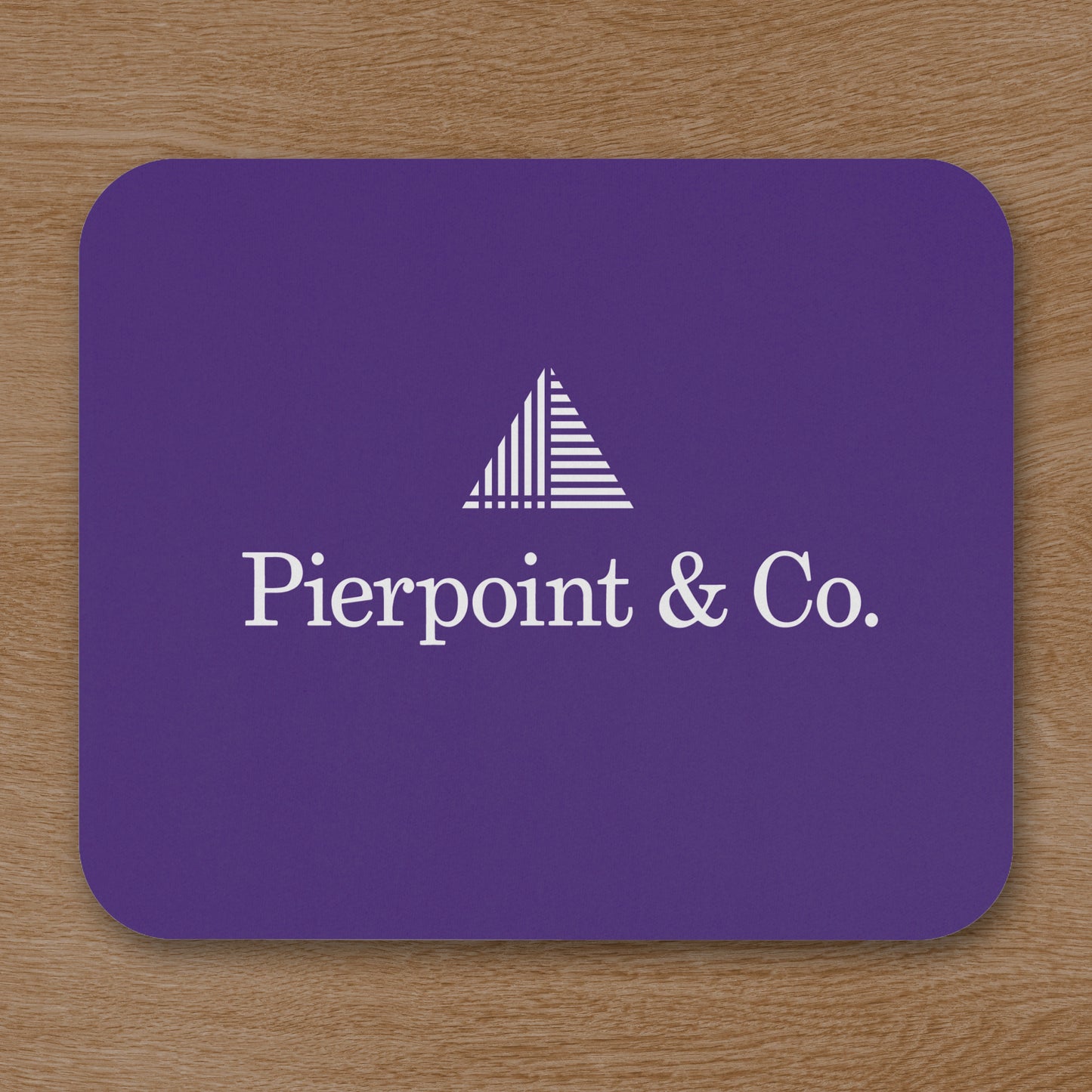 Topdown view of Purple 9x8 mouse pad featuring the Pierpoint & Co. logo inspired by the HBO series Industry, shown on wooden desk.