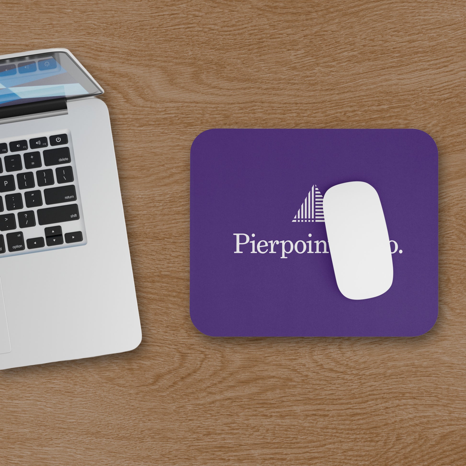 Purple 9x8 mouse pad featuring the Pierpoint & Co. logo inspired by the HBO series Industry, shown on wooden desk with mouse and computer.
