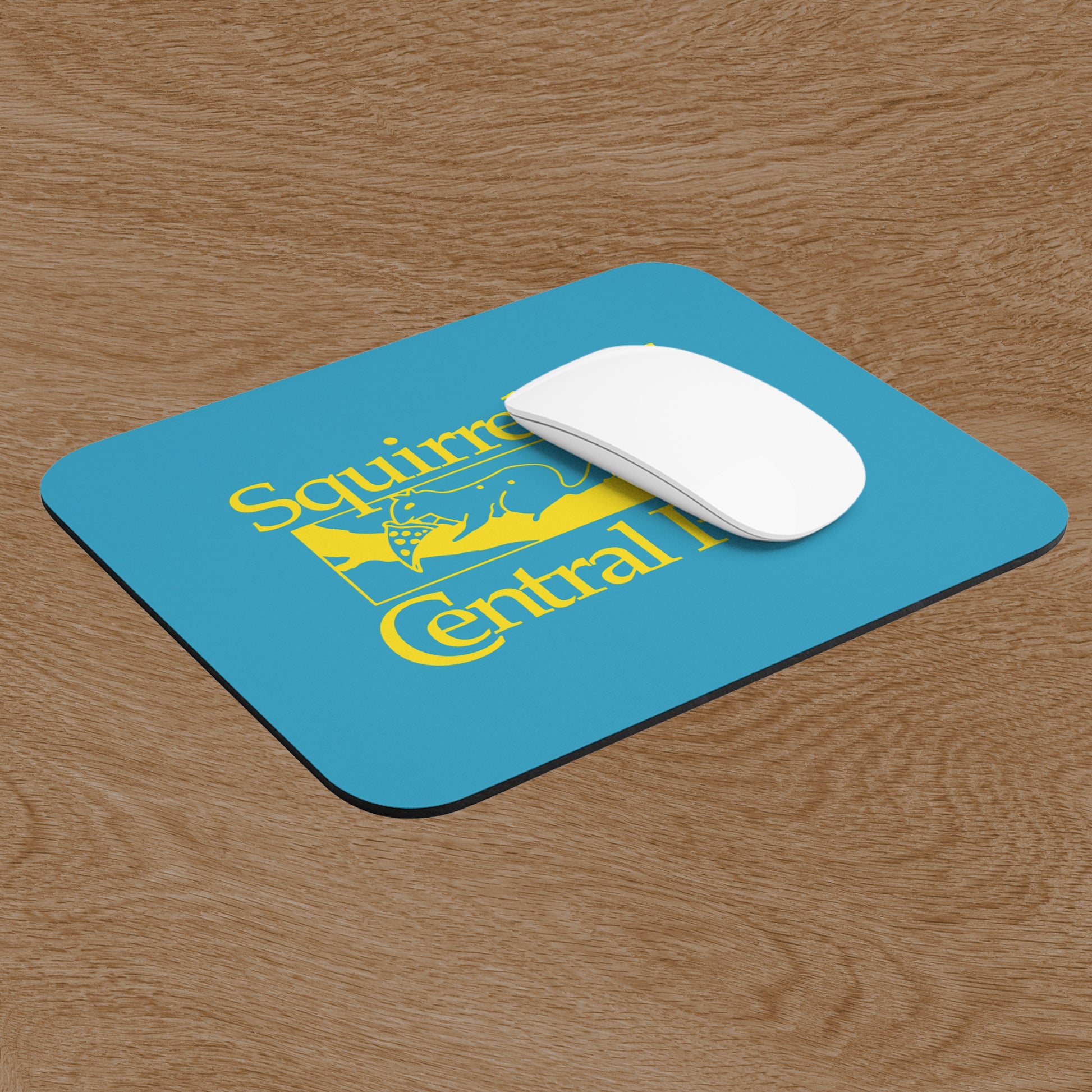 Angled view of Squirrels Of Central Park mouse pad in gold on blue inspired by Bad Sisters TV show, shown on a wooden desk with a mouse.