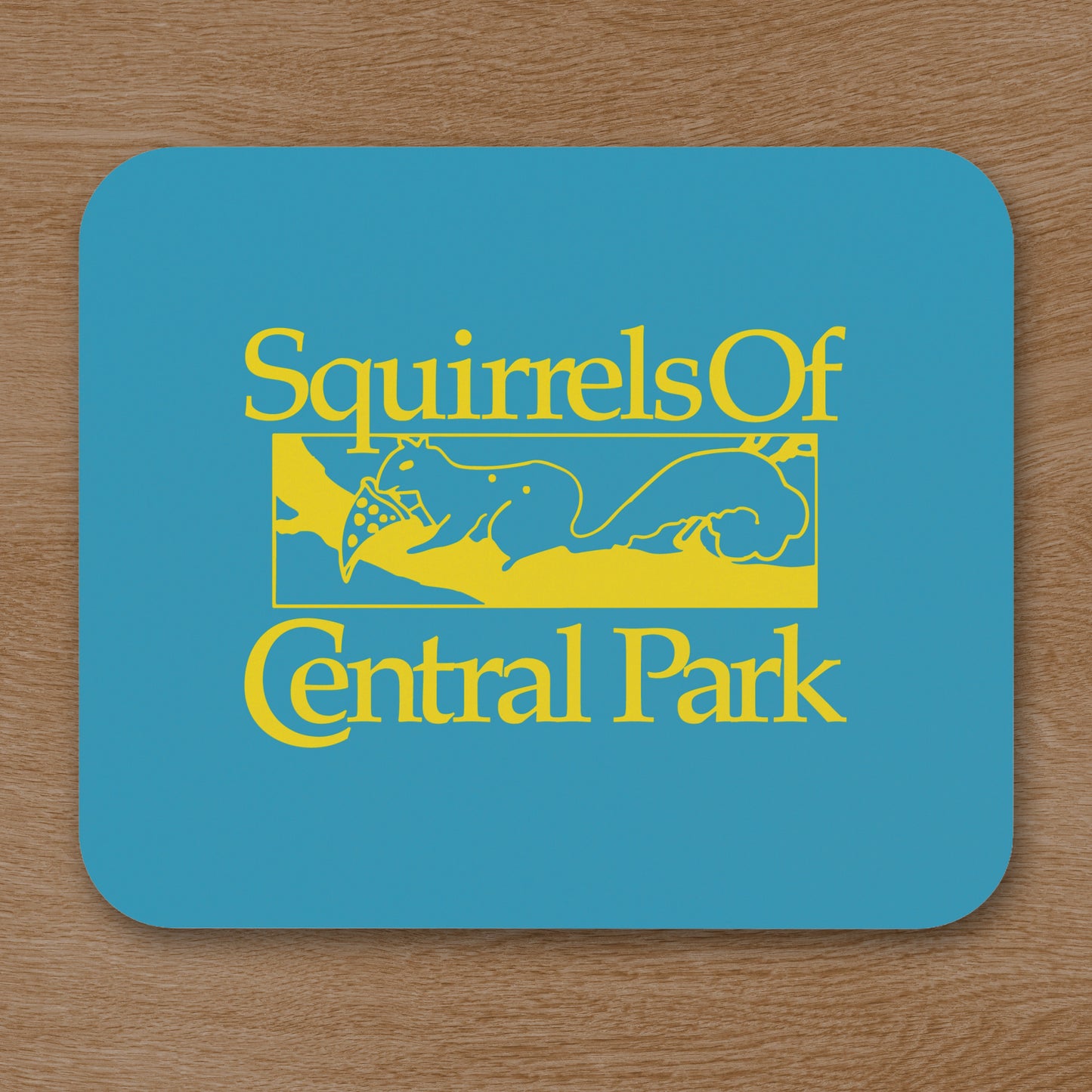 Topdown view of Squirrels Of Central Park mouse pad in gold on blue inspired by Bad Sisters TV show, shown on a wooden desk.