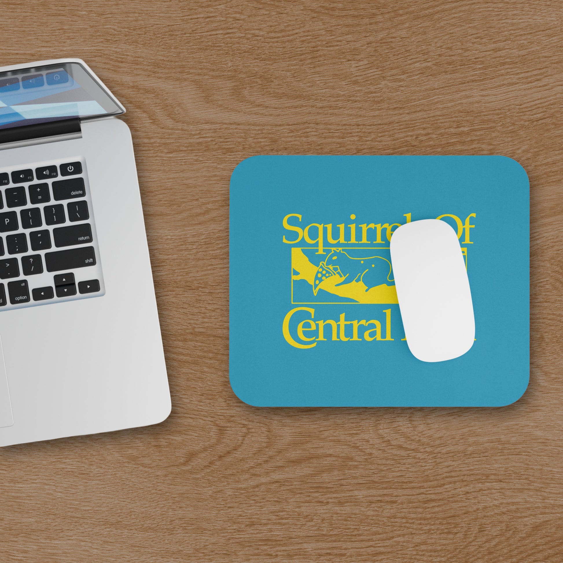 Squirrels Of Central Park mouse pad in gold on blue inspired by Bad Sisters TV show, shown on a wooden desk with a mouse and a computer.