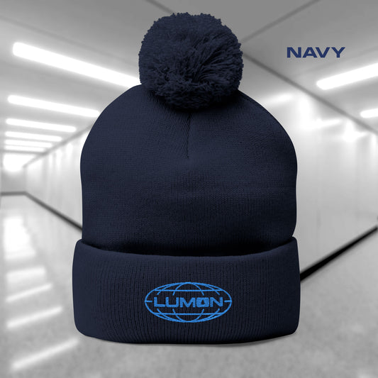 Navy Blue colored Pom-Pom Winter Knit Hat featuring the embroidered blue logo of Lumon Industries from the Apple TV Show Severance.