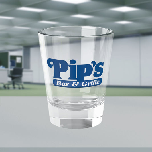 Mockup of a 1.5 oz ounce clear shot glass featuring the Pips Bar and Grill logo from the Apple TV show Severance printed on one side, shown in the Severed Floor of the Lumon Industries building. 
