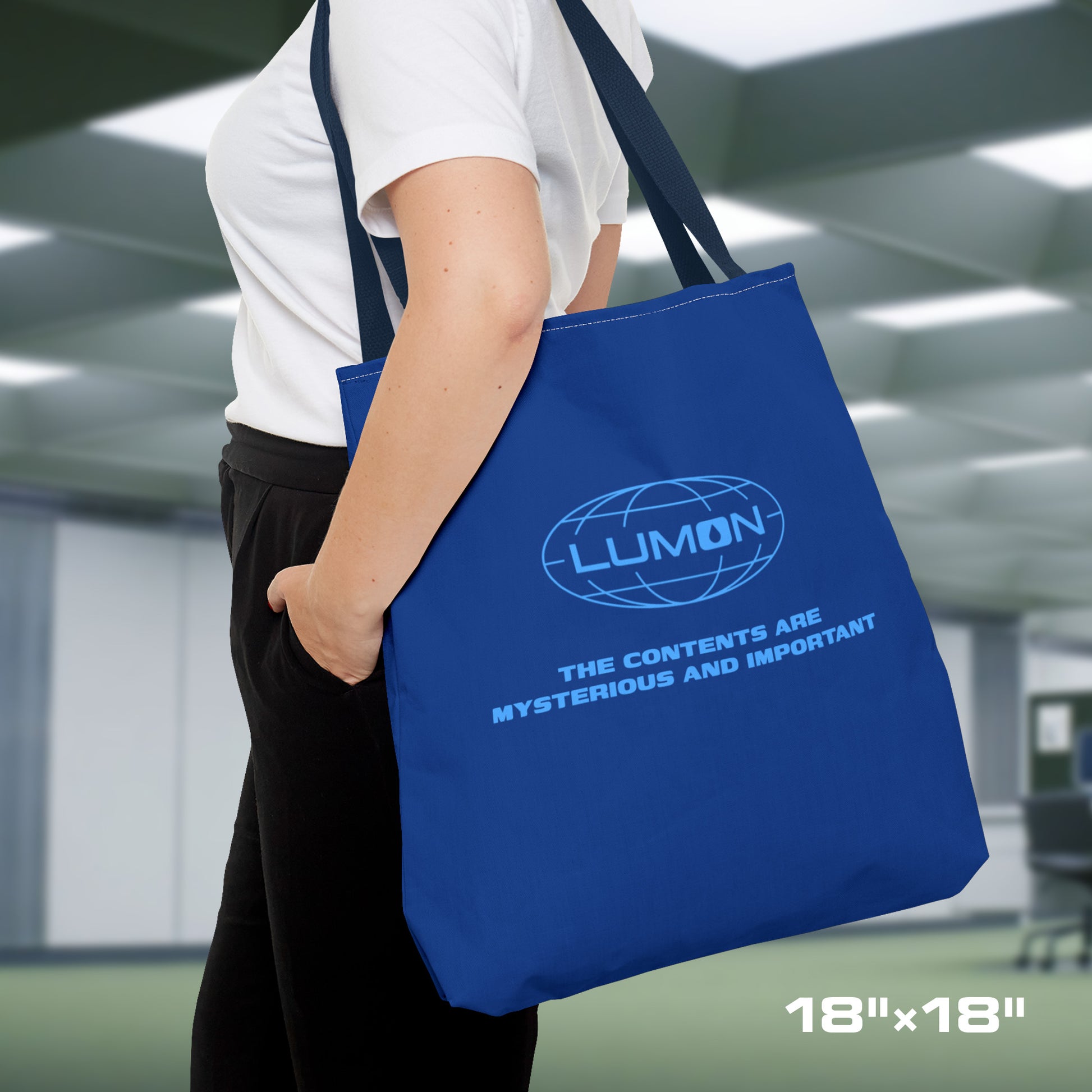 Female model carrying a 18" x 18" Blue Tote Bag featuring the logo of Lumon Industries from the Apple TV Show Severance, along with added customizable text by the customer, which is "THE CONTENTS ARE MYSTERIOUS AND IMPORTANT."