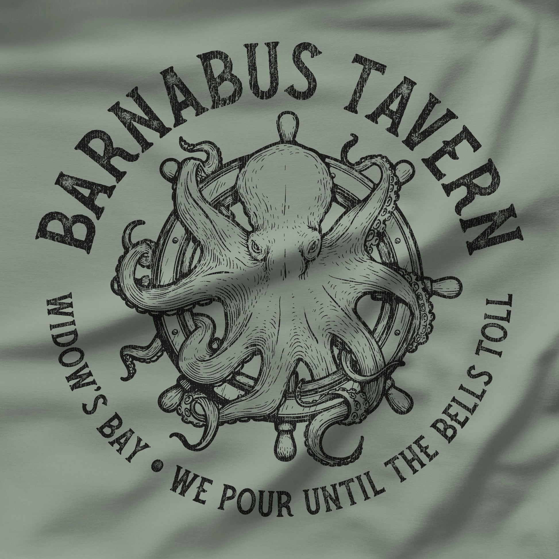 Closeup of Sage green tee with vintage engraved Barnabus Tavern octopus and ship's wheel Widow's Bay design