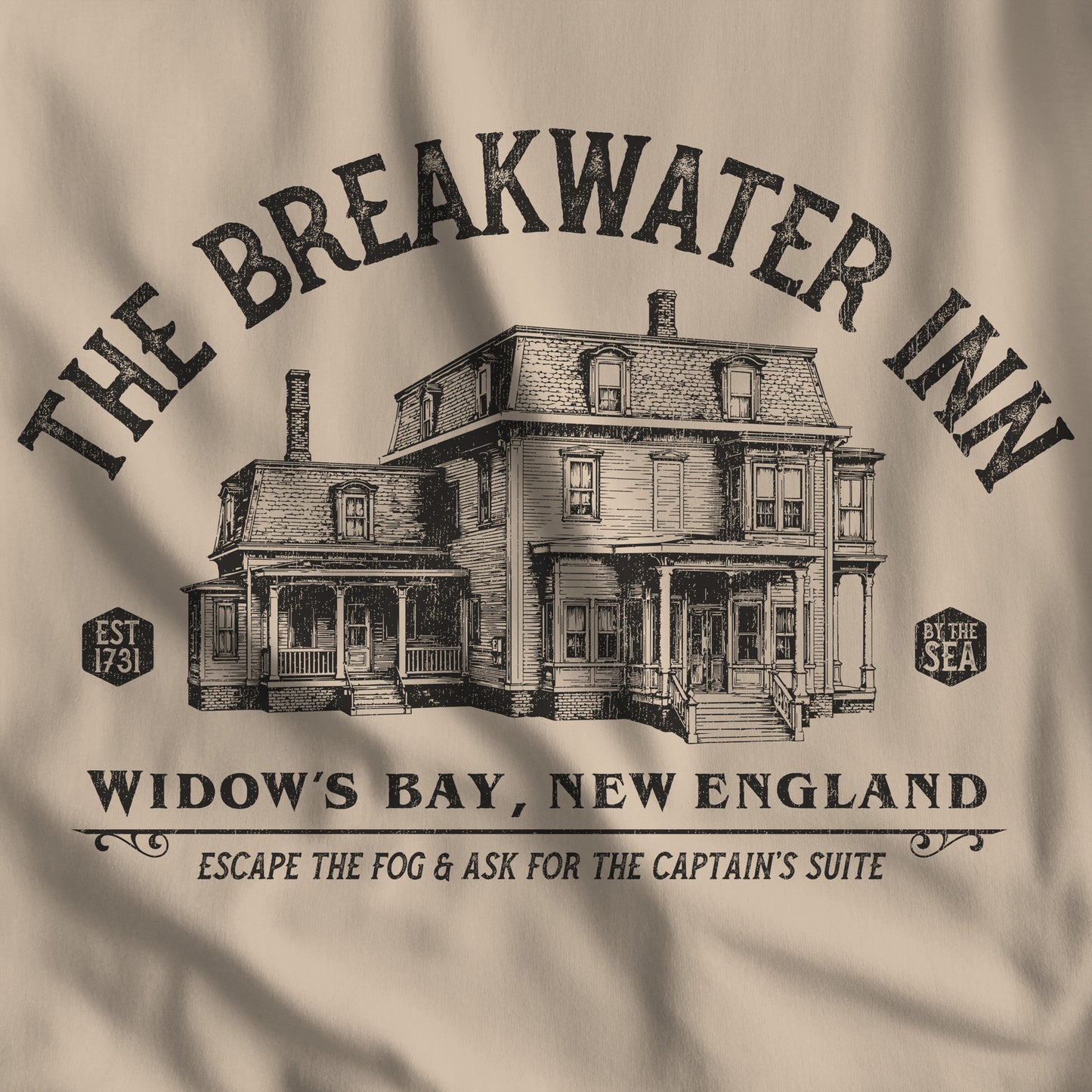 Closeup of 'The Breakwater Inn' vintage illustrated t-shirt inspired by Widow's Bay Apple TV series, soft Bella+Canvas cotton fan tee