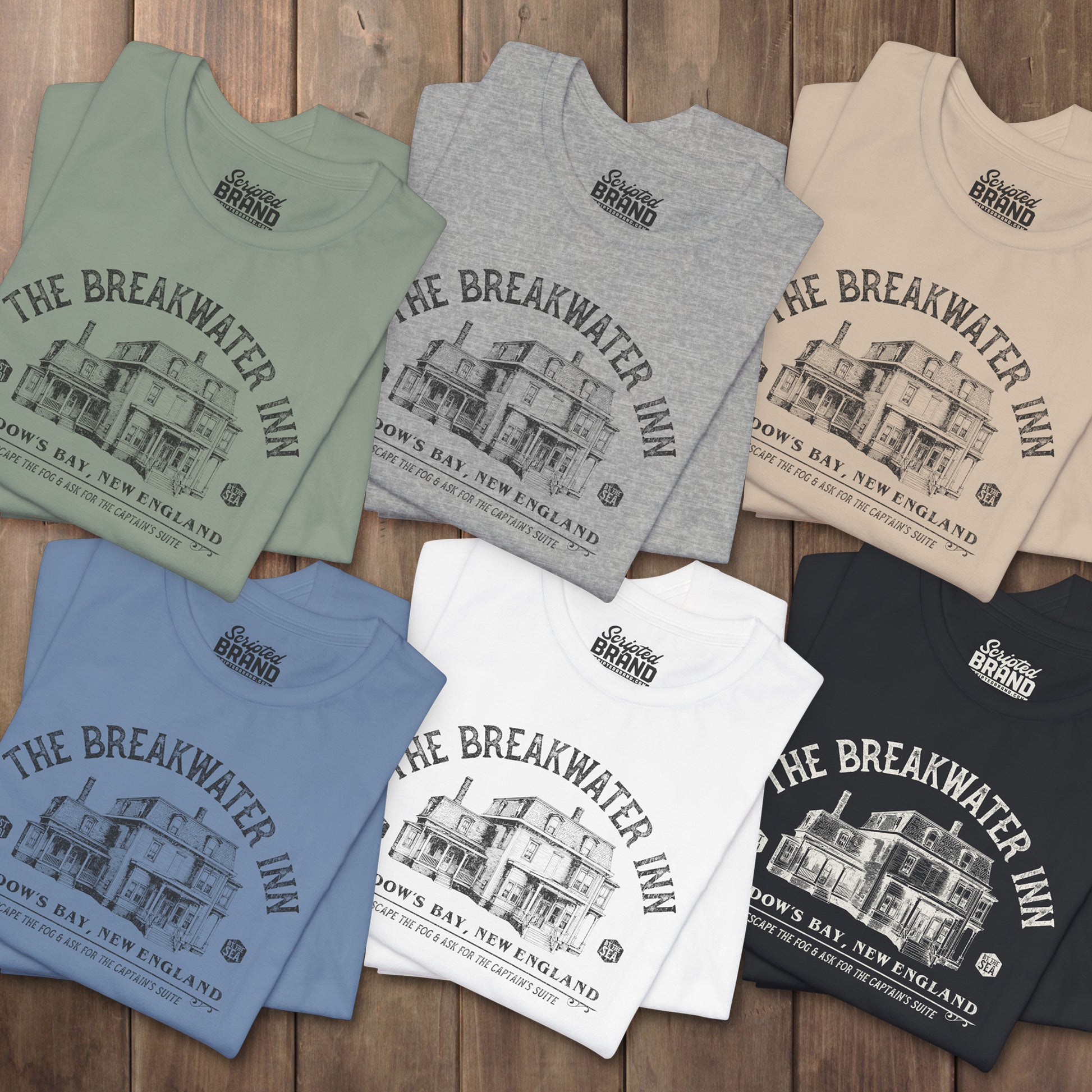 Six folded 'The Breakwater Inn' vintage illustrated t-shirts inspired by Widow's Bay Apple TV series, soft Bella+Canvas cotton fan tee