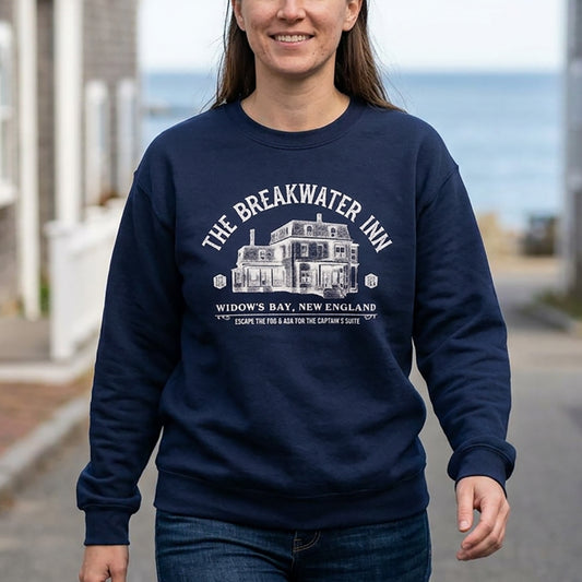 Person wearing Navy blue crewneck sweatshirt with Breakwater Inn Widow's Bay New England hotel graphic
