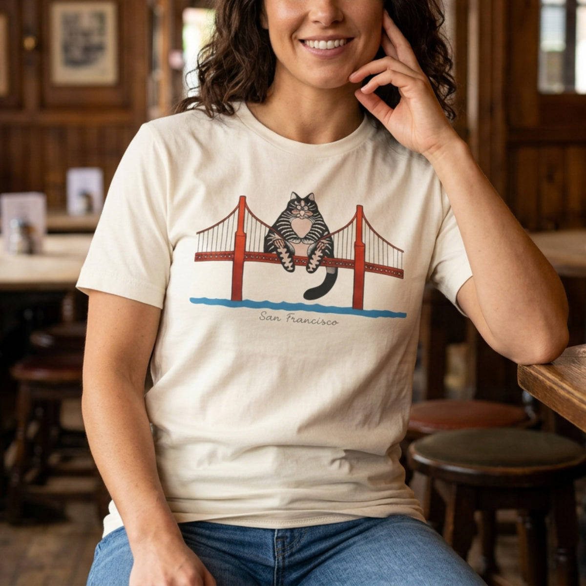 Person wearing natural cream tee with illustrated tabby cat sitting on the Golden Gate Bridge, San Francisco, Project Hail Mary