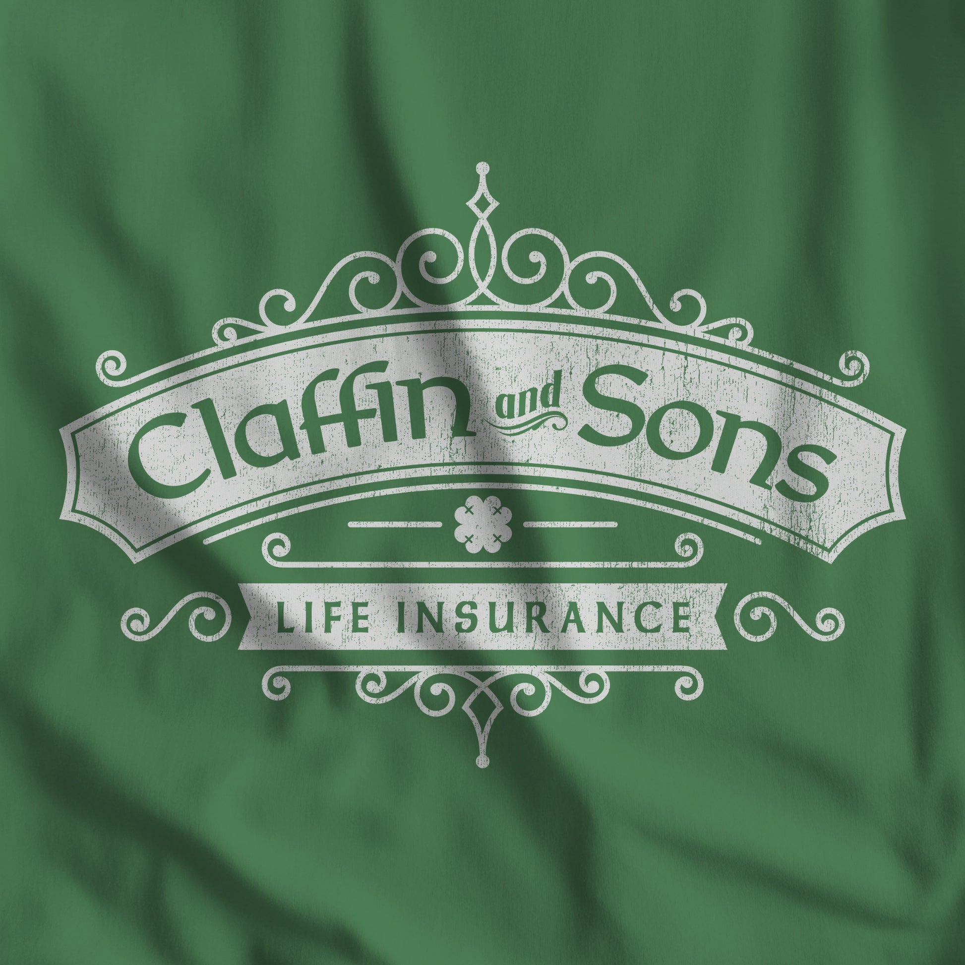 Closeup of Green tee with vintage distressed Claffin and Sons Life Insurance, Bad Sisters TV show graphic