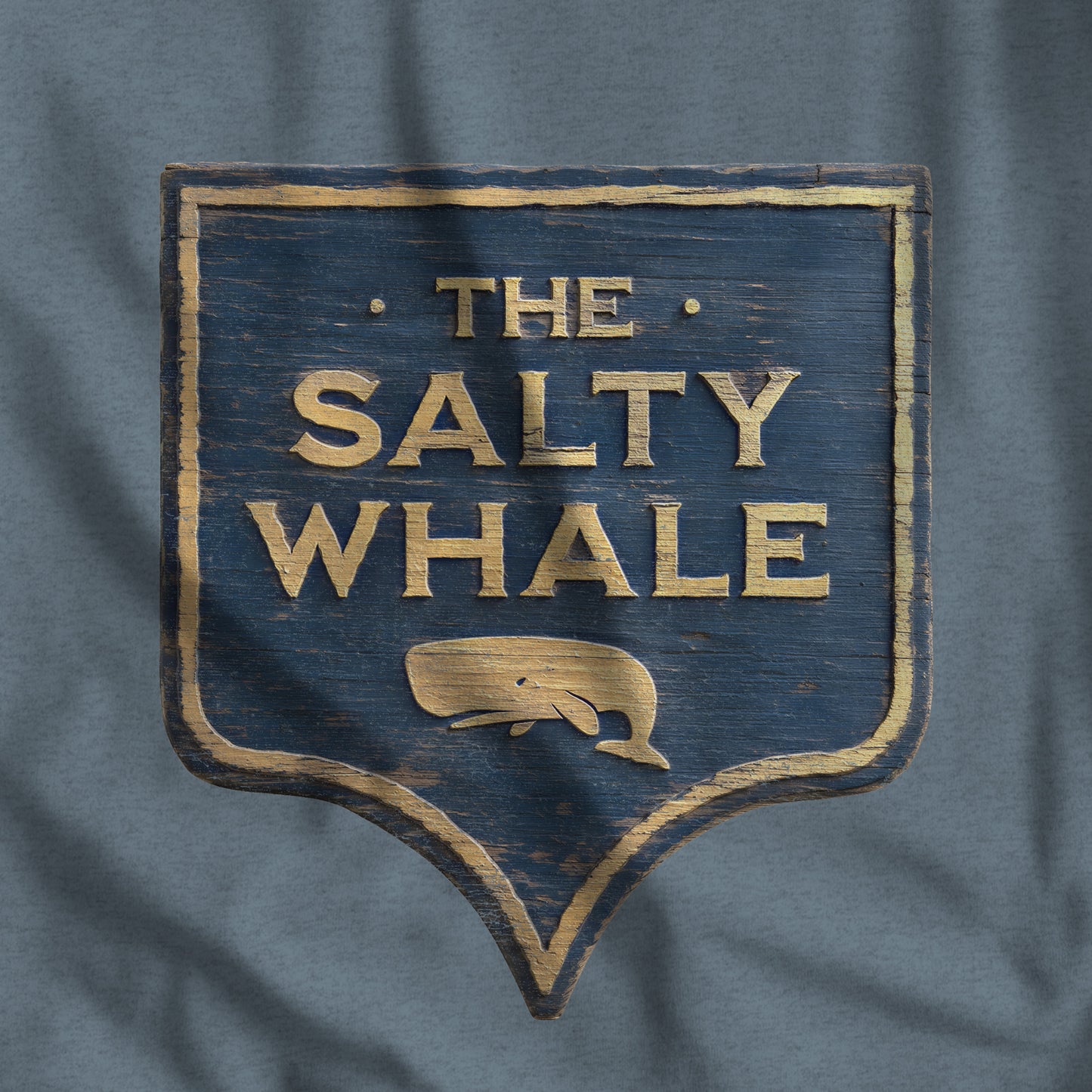 Closeup of 'The Salty Whale' weathered carved-wood pub sign t-shirt inspired by Widow's Bay Apple TV series, heather Bella+Canvas tee