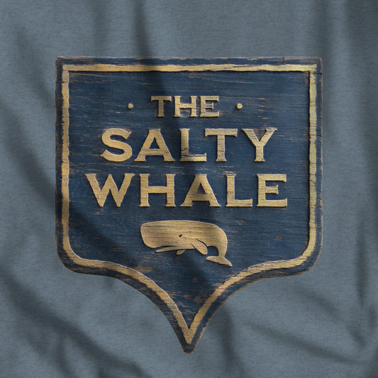 Closeup of 'The Salty Whale' weathered carved-wood pub sign t-shirt inspired by Widow's Bay Apple TV series, heather Bella+Canvas tee