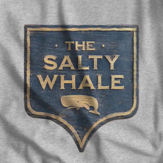 Closeup of heather gray 'The Salty Whale' weathered carved-wood pub sign t-shirt inspired by Widow's Bay Apple TV series, heather Bella+Canvas tee