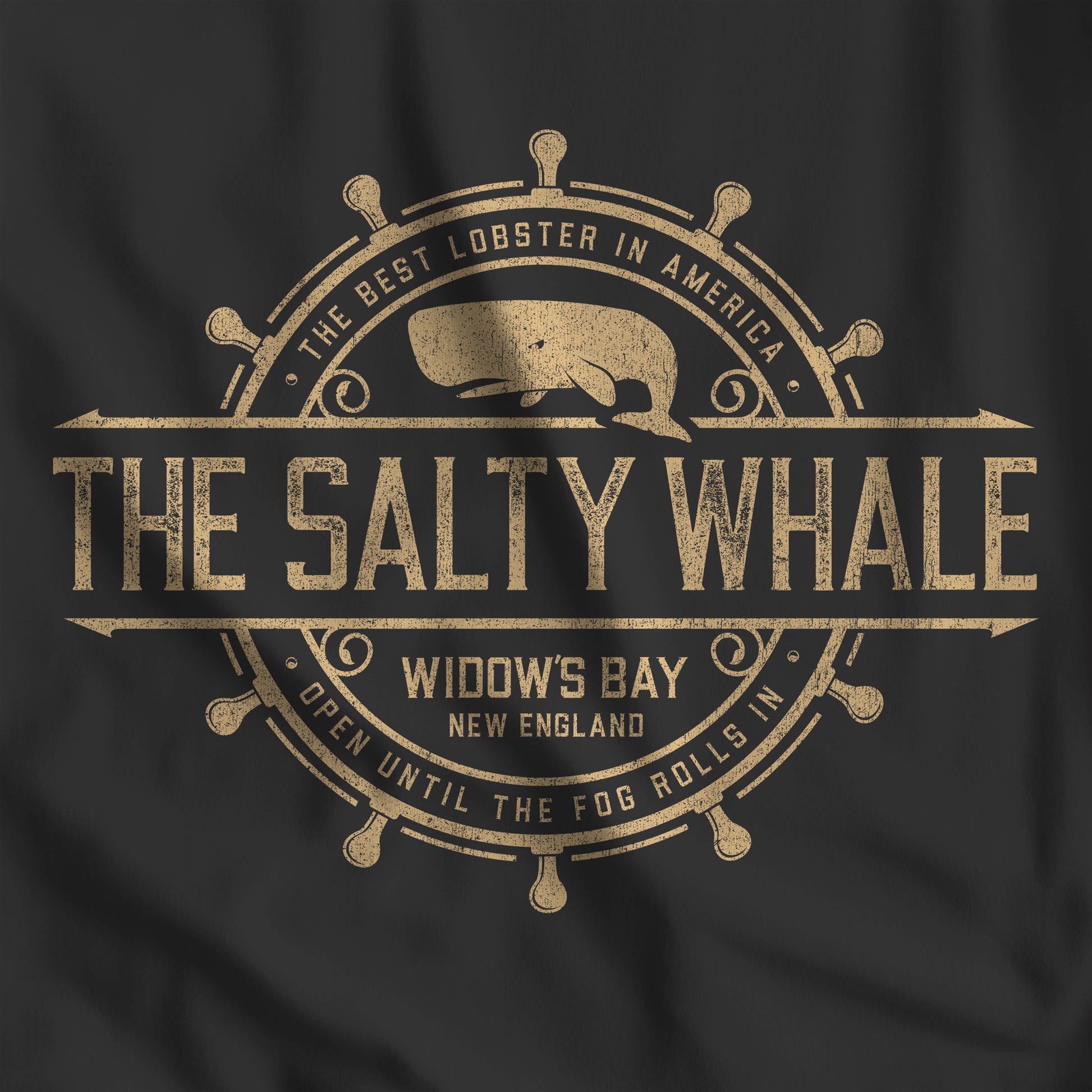 Closeup of black 'The Salty Whale' vintage distressed pub logo t-shirt inspired by Widow's Bay Apple TV series, soft Bella+Canvas cotton tee