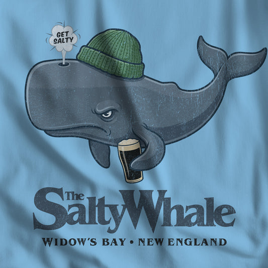 Closeup of ocean blue 'The Salty Whale' cartoon mascot t-shirt inspired by Widow's Bay Apple TV series, soft Bella+Canvas cotton pub fan tee