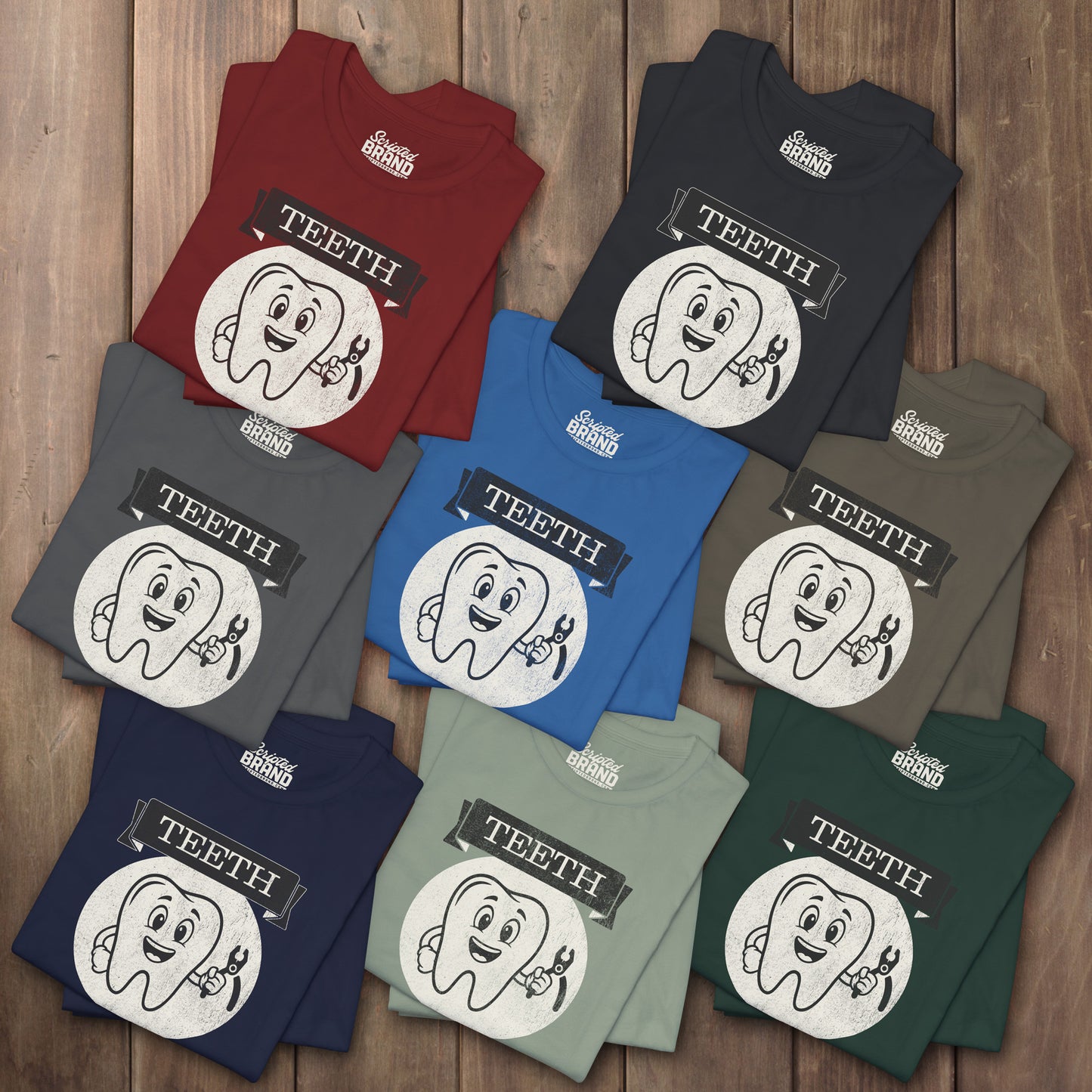 Eight folded Bella+Canvas tees with the vintage TEETH board game box cover from Widow's Bay, a smiling tooth holding pliers