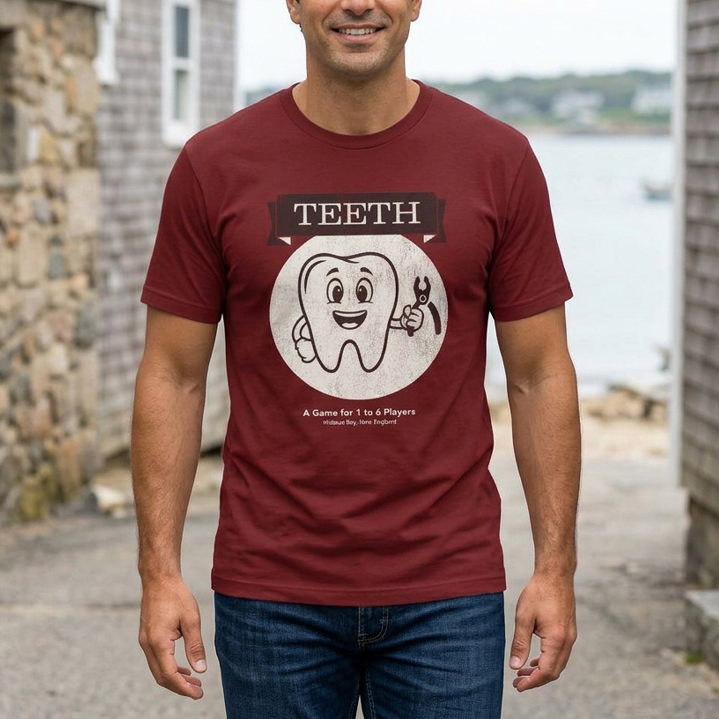 Person wearing Red Bella+Canvas tee with the vintage TEETH board game box cover from Widow's Bay, a smiling tooth holding pliers