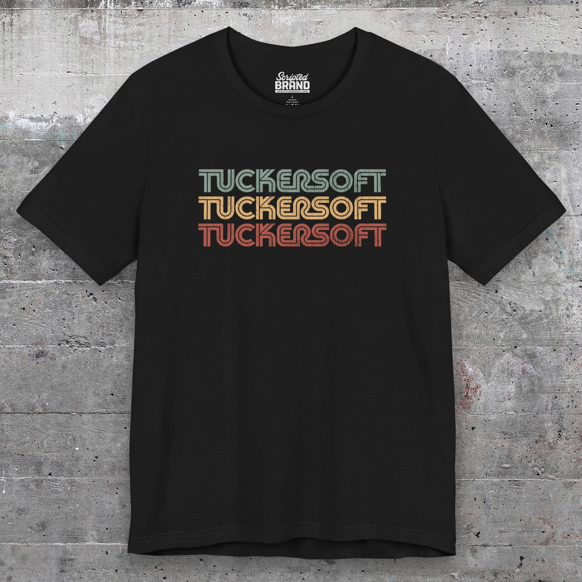 Front view of a black soft Bella+Canvas 3001 short-sleeve t-shirt tee featuring a logo graphic of the 1980s fictional video game company Tuckersoft inspired by the TV show Black Mirror and the episode Bandersnatch in a vintage distressed style, sold by ScriptedBrand.