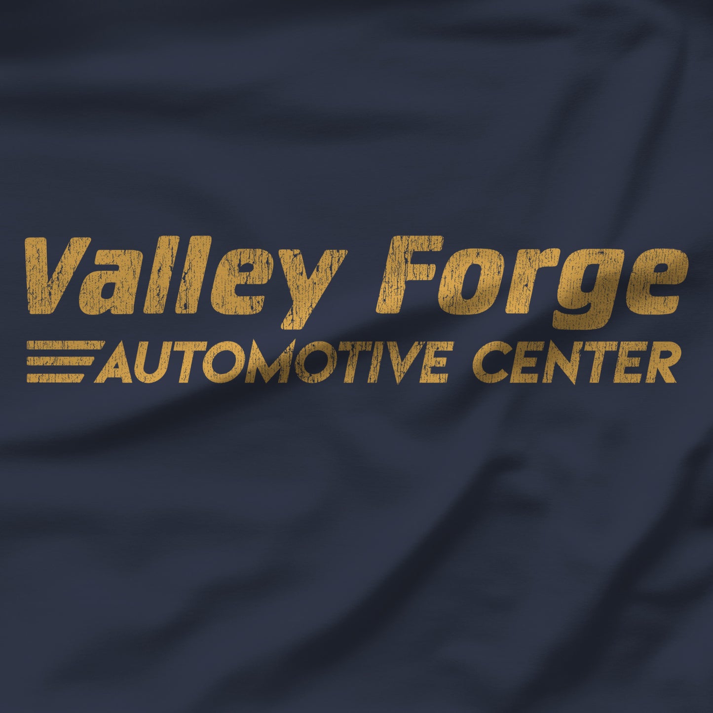 Closeup of Navy tee with vintage gold Valley Forge Automotive Center auto shop logo from comedian Shane Gillis Tires TV show