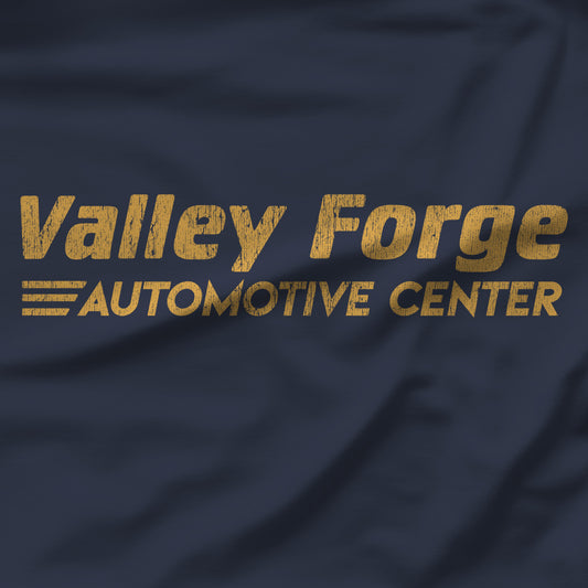 Closeup of Navy tee with vintage gold Valley Forge Automotive Center auto shop logo from comedian Shane Gillis Tires TV show
