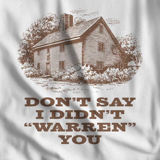 Closeup of White Bella+Canvas tee with vintage Warren house illustration and the pun "Don't Say I Didn't Warren You" from Widow's Bay show