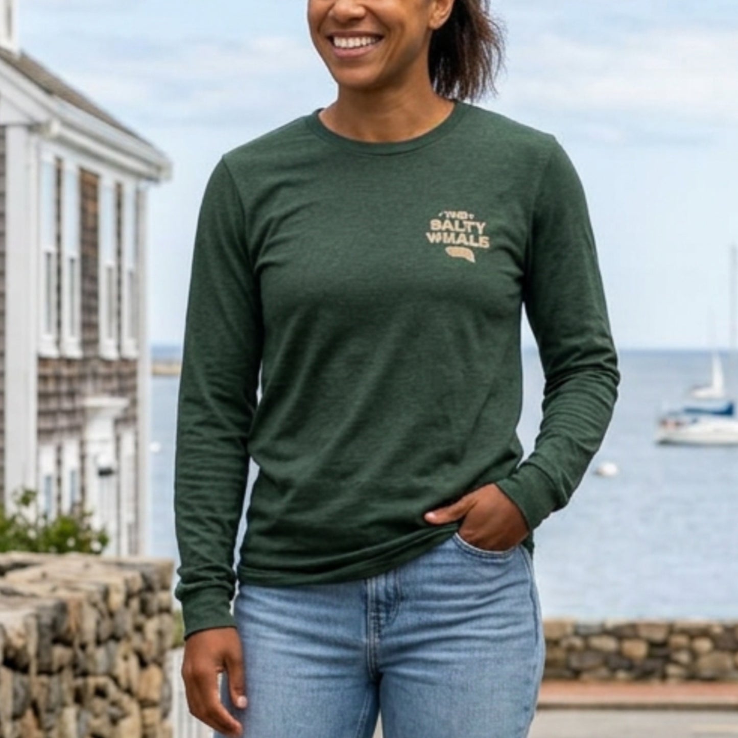Front of person wearing Heather forest green long sleeve tee with vintage gold The Salty Whale logos from the TV show Widow's Bay nautical on front and back