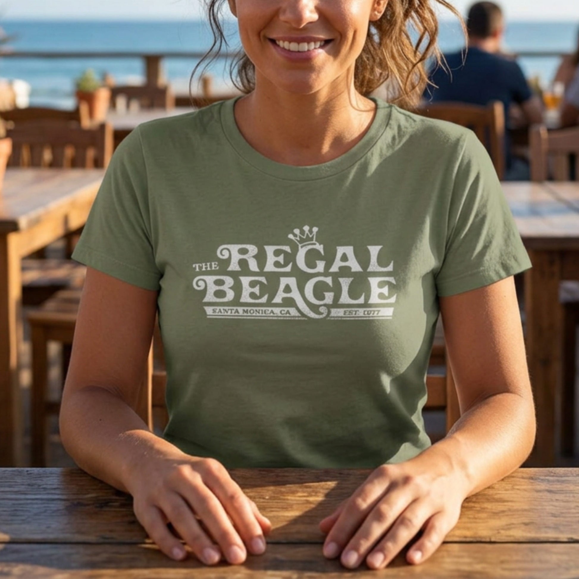 Woman wearing Olive green womens boyfriend tee with vintage distressed Regal Beagle Three's Company logo