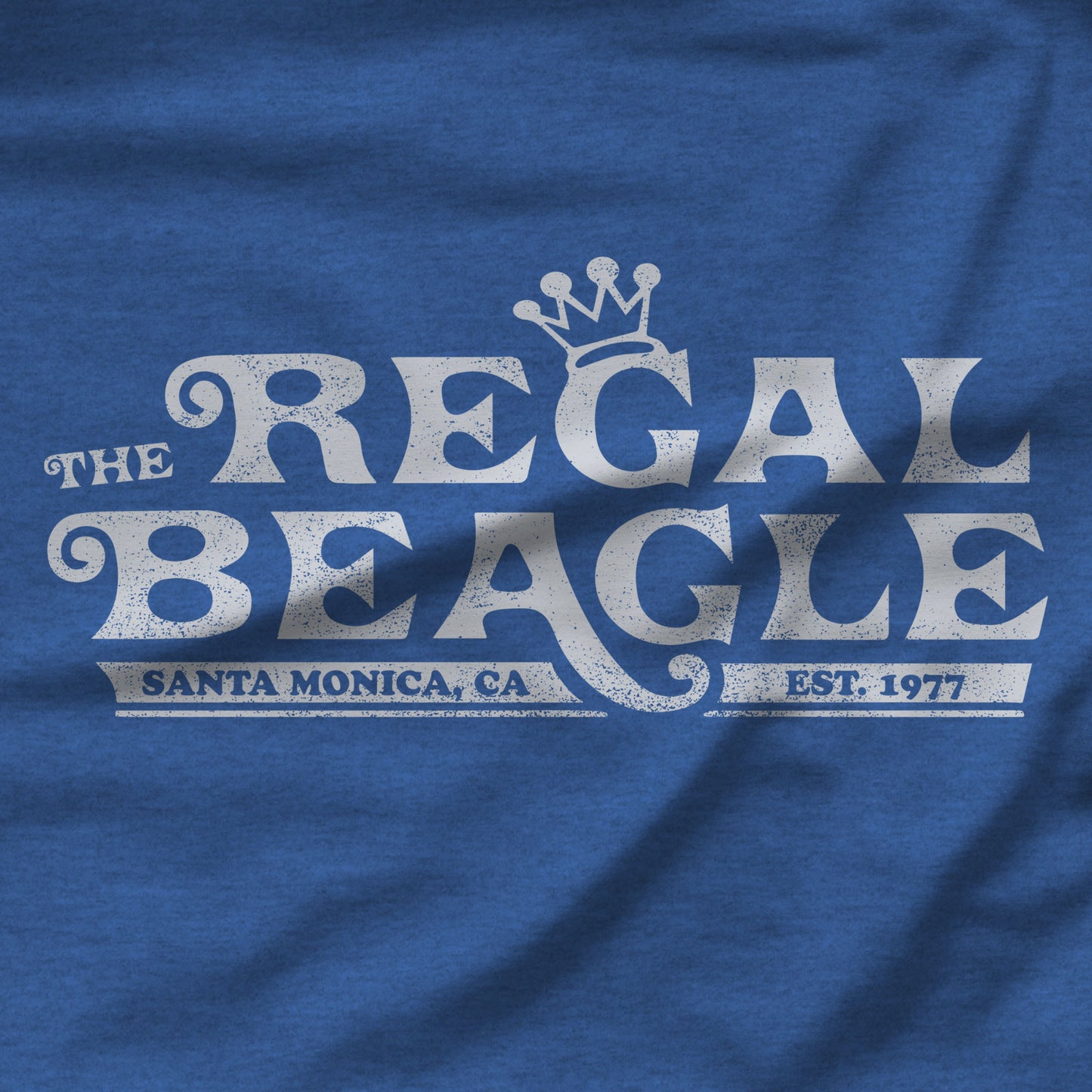 Closeup of Heather royal blue womens v-neck tee with vintage distressed Regal Beagle Three's Company logo
