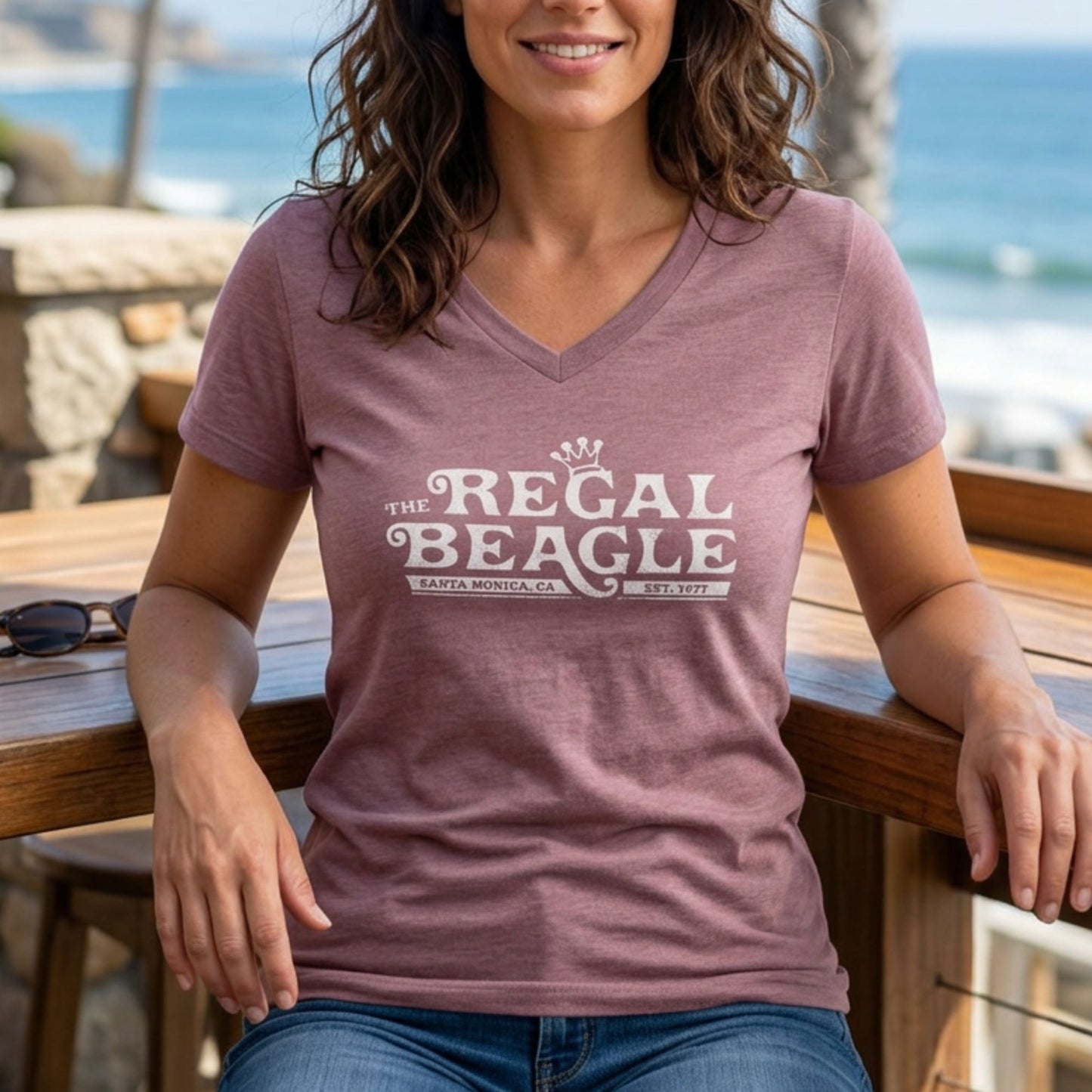 Person wearing Heather mauve womens v-neck tee with vintage distressed Regal Beagle Three's Company logo