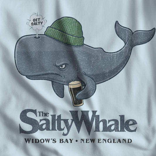 Closeup light blue Comfort Colors tank with the Salty Whale logo from Widow's Bay, a beanie-wearing cartoon whale drinking dark beer