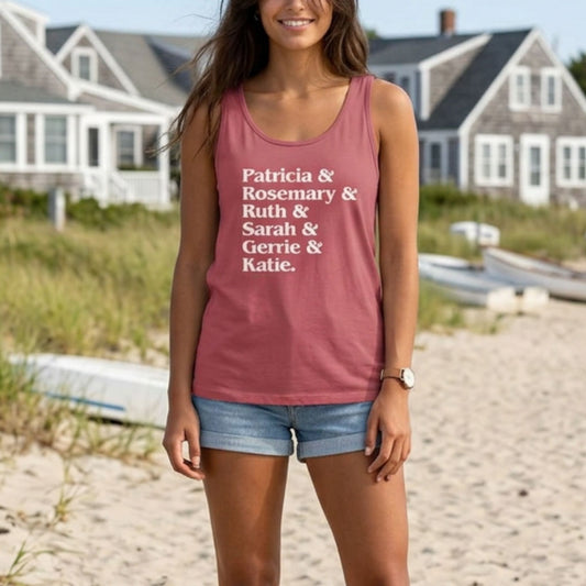 Woman at beach wearing crimson red garment-dyed Comfort Colors tank top with stacked Women of Widow's Bay show names in ampersand list including Patricia, Ruth, Rosemary