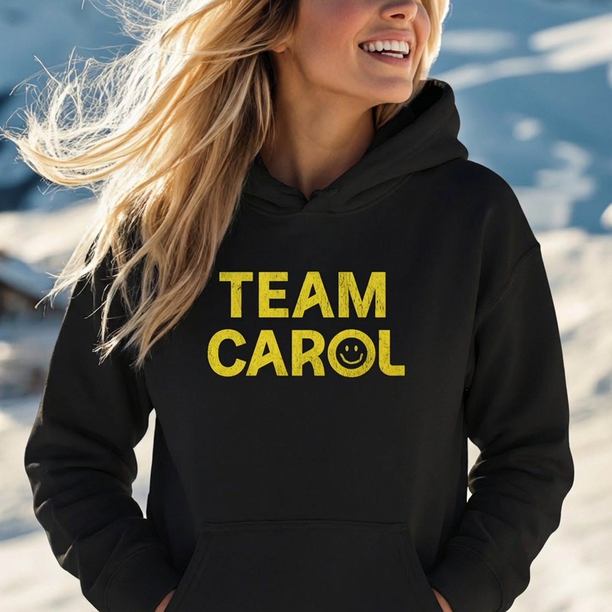 Woman wearing black unisex Heavy Blend pullover hoodie sweatshirt with TEAM CAROL vintage distressed smiley graphic