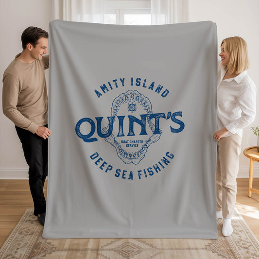 Two people holding 60x80 large Gray velveteen plush blanket with vintage blue Quint’s Deep Sea Fishing logo inspired by Jaws.