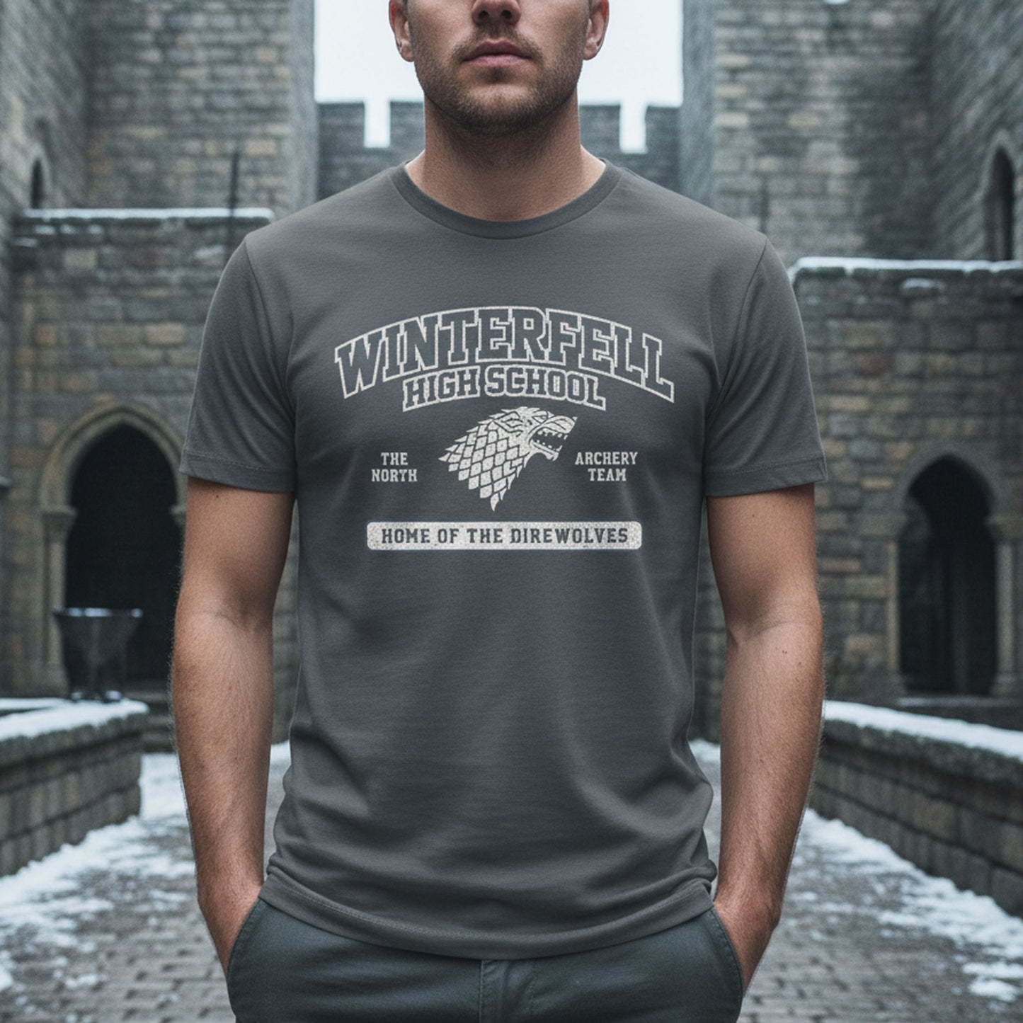 Man wearing Asphalt Gray Winterfell High School t-shirt with vintage direwolf graphic inspired by Game of Thrones.
