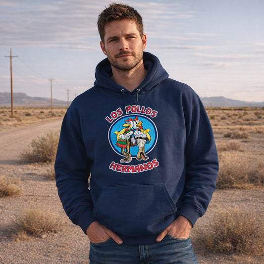 Man wearing Navy blue pullover hoodie with vintage distressed Los Pollos Hermanos logo from Breaking Bad on chest, standing in a desert.