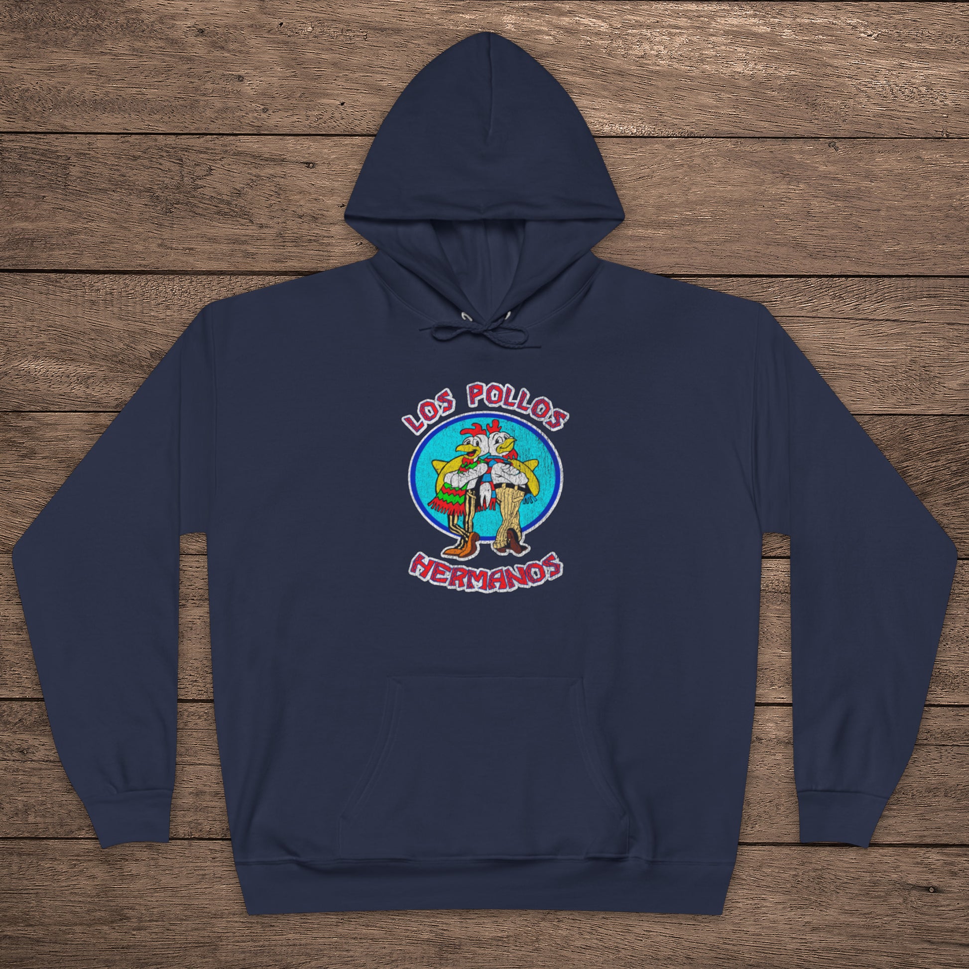 navy blue pullover hoodie with vintage distressed Los Pollos Hermanos logo from Breaking Bad on chest, shown on a wood floor.